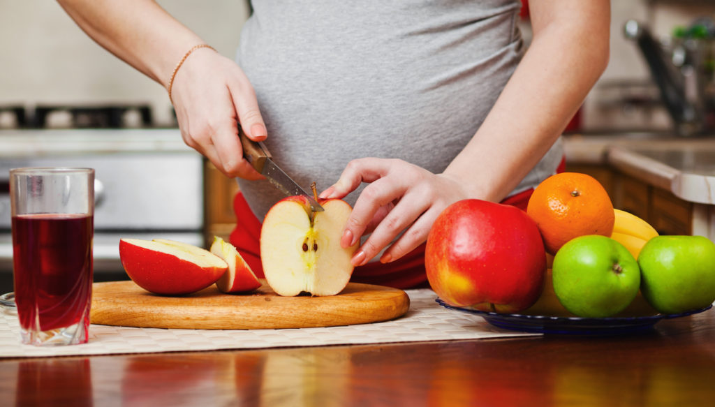 pregnant women slicing fruit