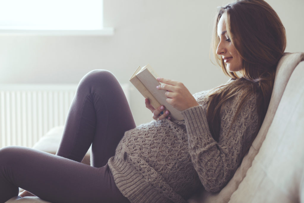 Pregnant women reading about prenatal supplements