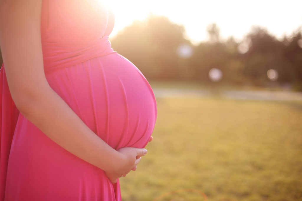 pregnant women outdoors in sunset